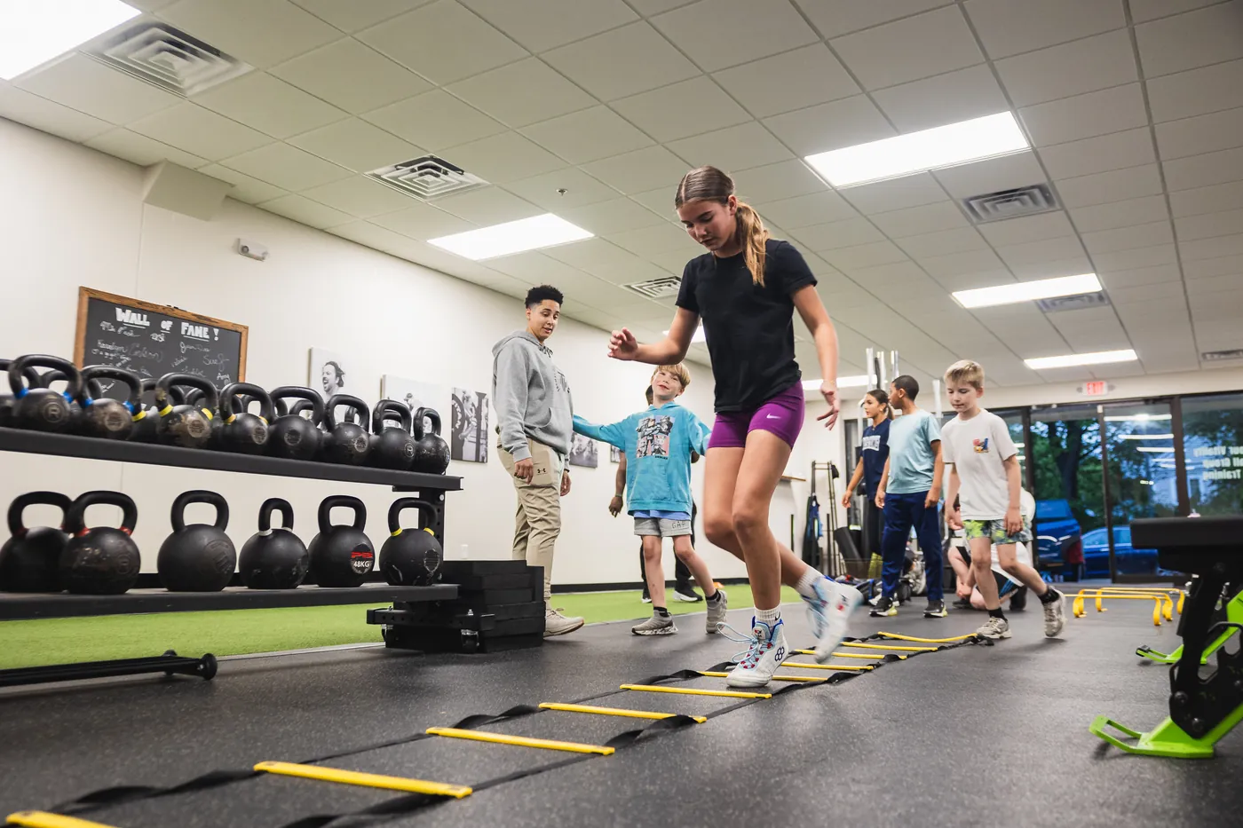 Young athletes running speed ladder drills with a coach at Thomas Fitness & Performance